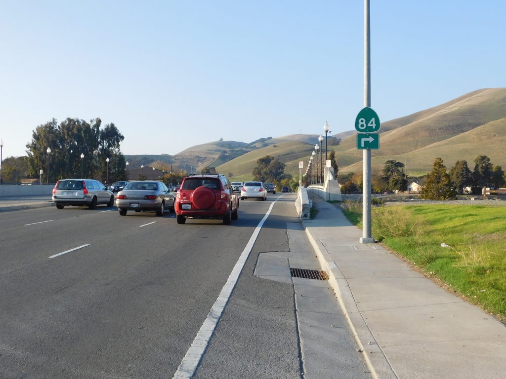 A terrifying paint-only bike lane on the edge of the highway with a gutter taking up much of its width