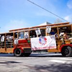 A picture of a historic trolly with VTA strike banners and union workers carrying signs