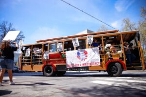 A picture of a historic trolly with VTA strike banners and union workers carrying signs